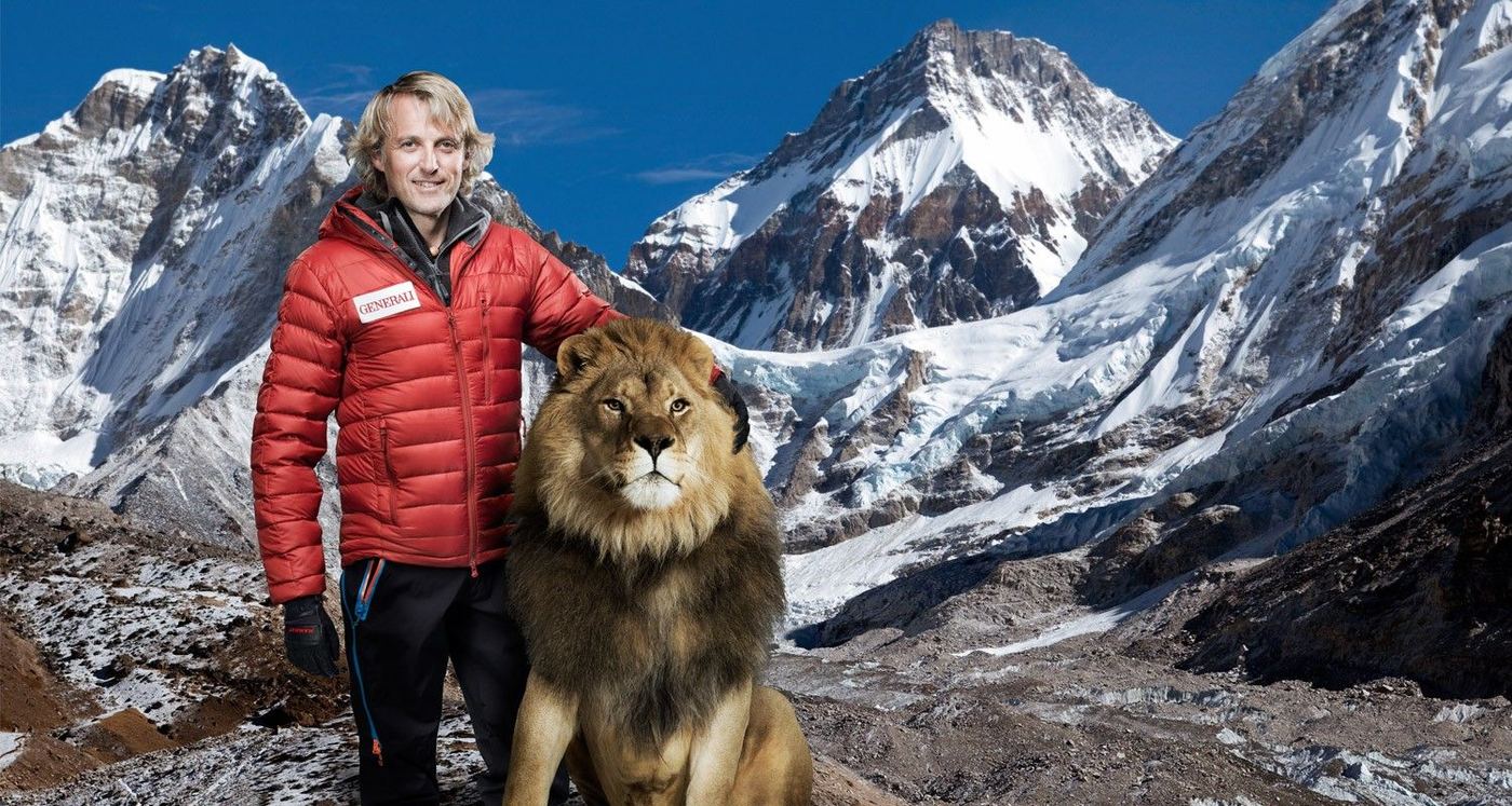 Jesús Calleja posa junto a un león ante montañas nevadas