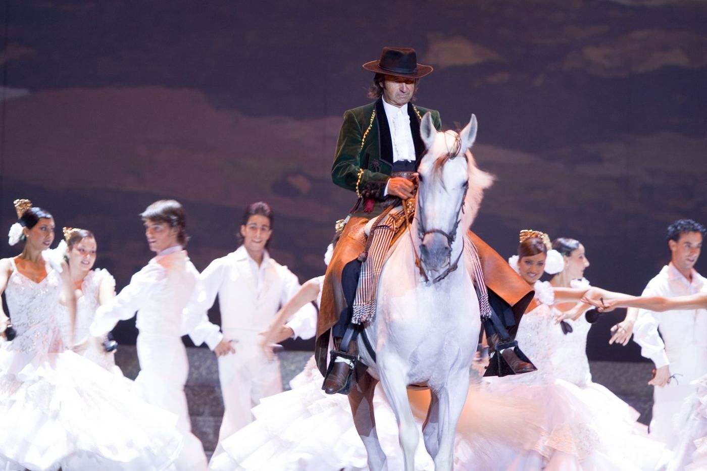 Juan Luis Malpartida a caballo entre bailarinas vestidas de blanco