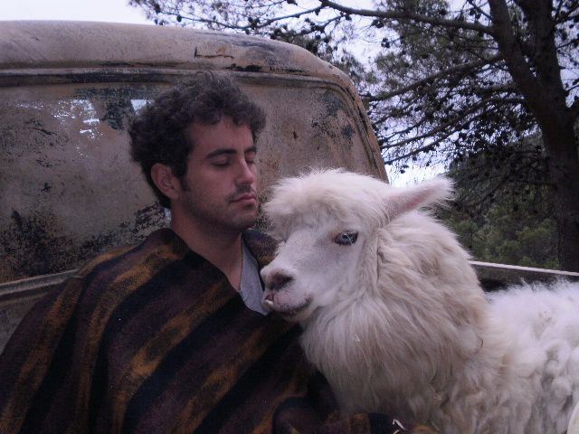 Un actor reclinado en la caja de una camioneta junto a una llama