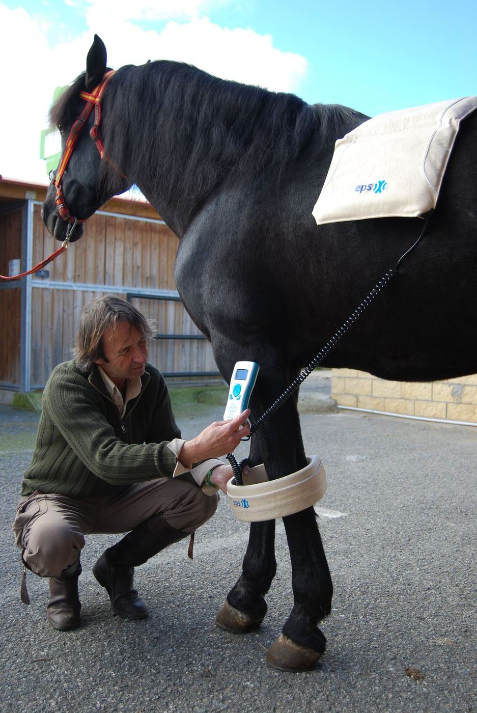 Juan Luis Malpartida agachado junto a un caballo negro durante el rodaje